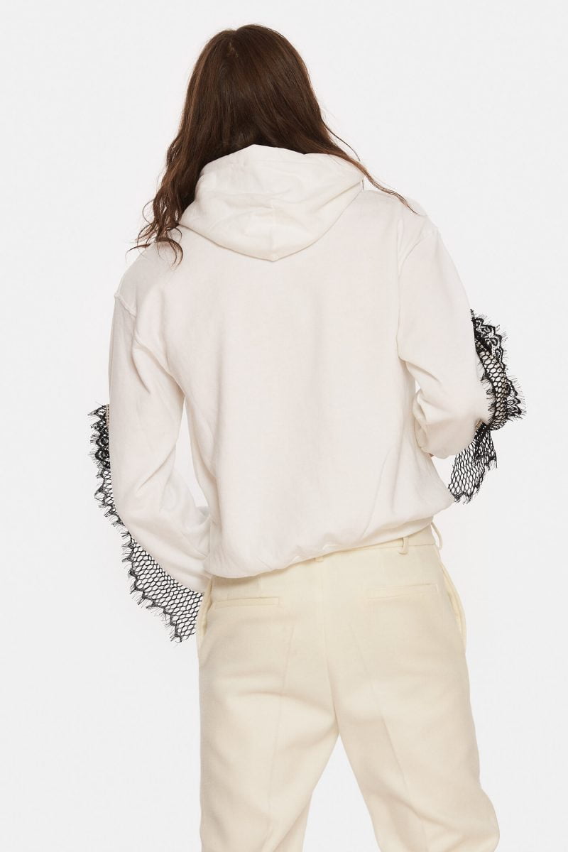 White hooded sweater with dropped shoulder. Embellished with rhinestones and lace on both sleeves.