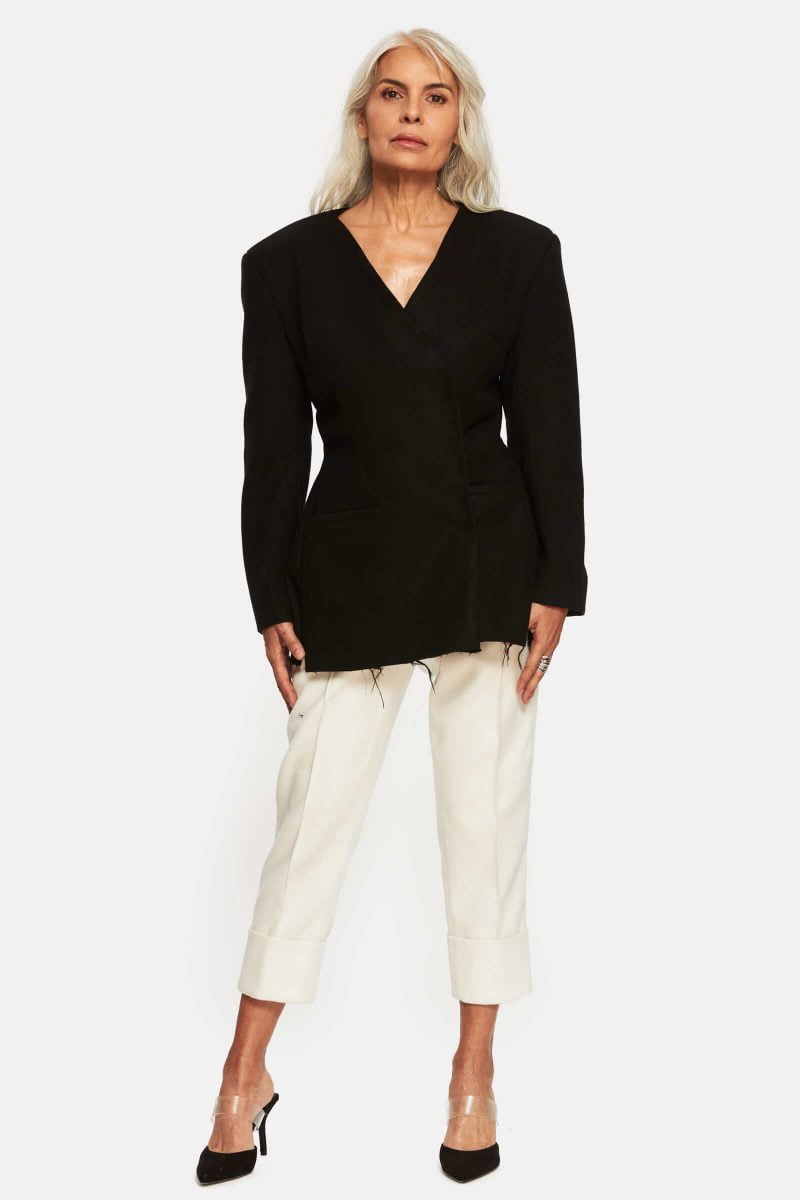 Fitted suit jacket with oversized shoulders. Two front pockets. Shredded hem detailing. Velcro closure. Fully lined.