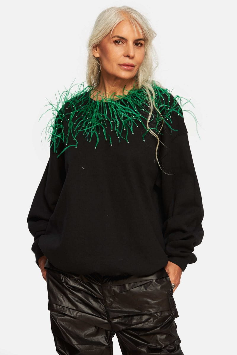 Loose sweater made out of cotton. Adorned with green feathers and rhinestones. Cleaning and maintenance suggestions: dry cleaning / wet feathers may stain the sweater.