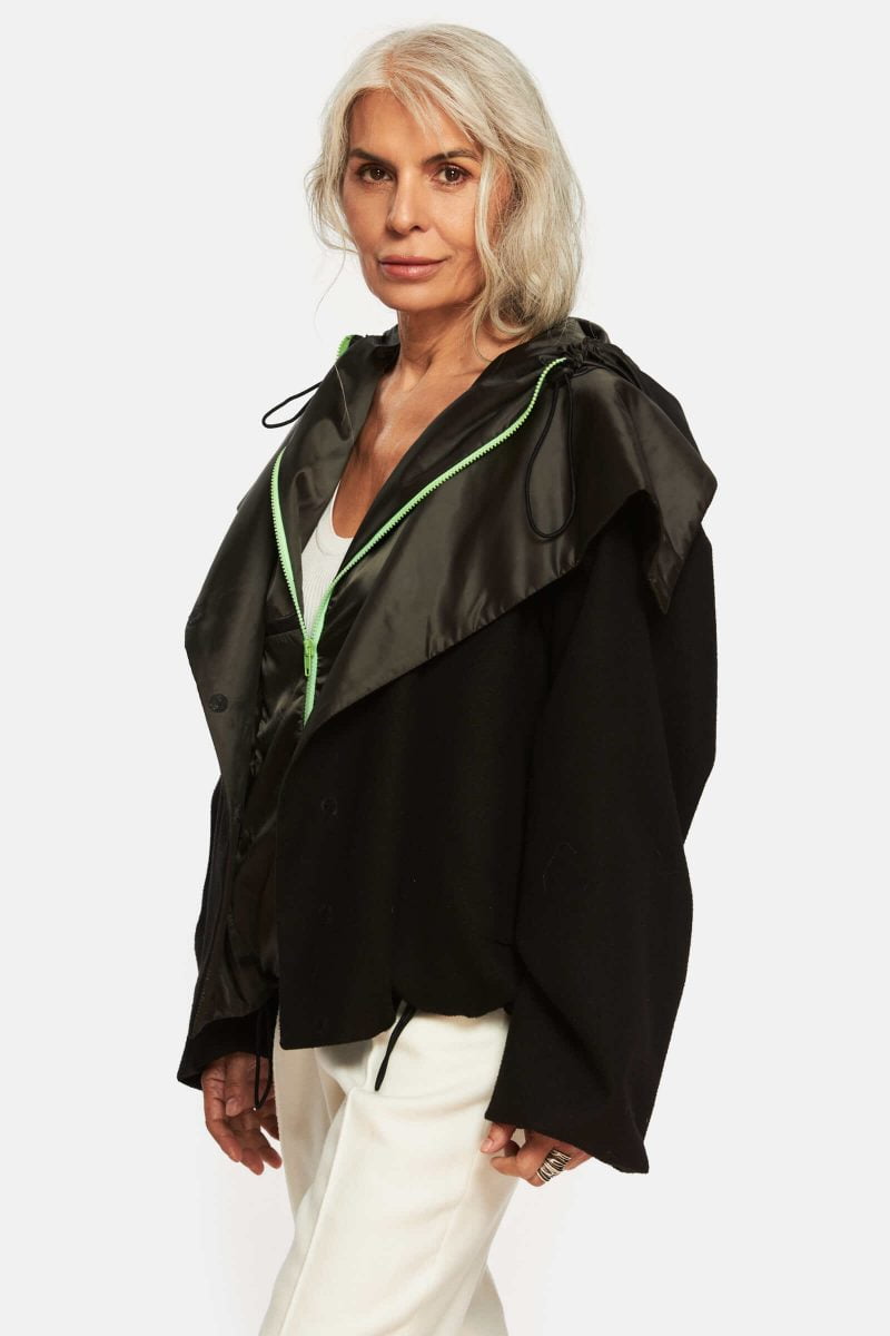 Quilted jacket with hood. Adjustable elastic cord at the hood and hem. Wool exterior with water repellant slicker details inside.The hood is water repellant. Front pockets and one interior pocket.